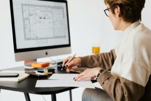 Kobieta projektująca plany architektoniczne w nowoczesnym biurze.